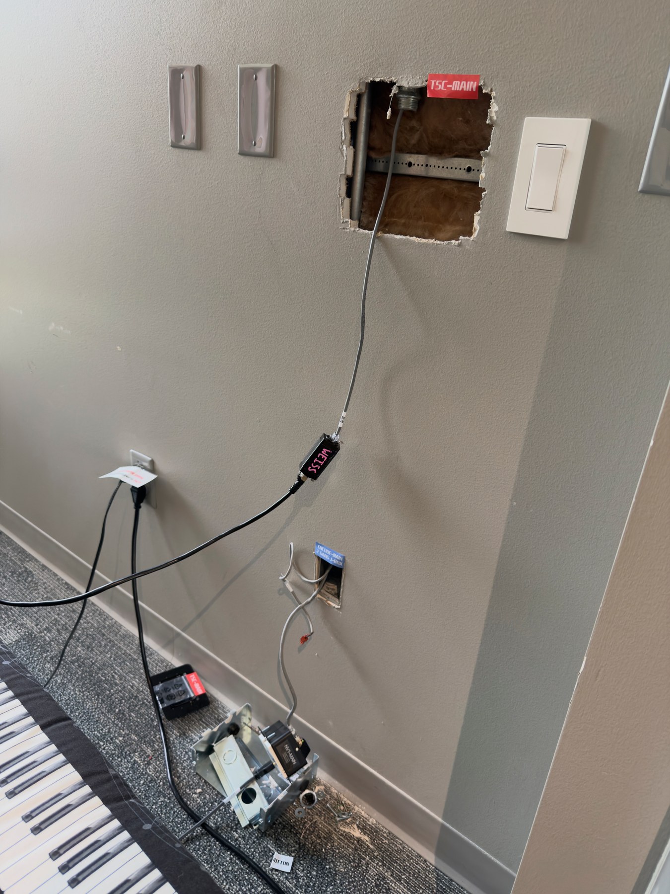 Open wall locations and labeled cabling during installation of a Classic Room touch panel and wall-plate connections
